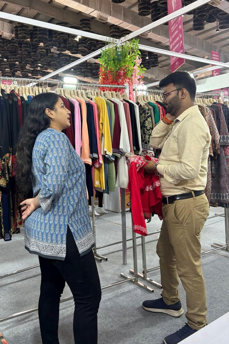 Snehal Creation founder Mahesh Agarwal showing kurtis to buyers at CMAI 2024, Mumbai